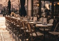Empty cafe terrace with neatly arranged chairs in early spring sunlight Royalty Free Stock Photo