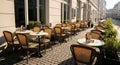 Empty cafe terrace with neatly arranged chairs in early spring sunlight Royalty Free Stock Photo
