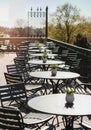 Empty cafe terrace with neatly arranged chairs in early spring sunlight Royalty Free Stock Photo