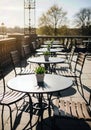 Empty cafe terrace with neatly arranged chairs in early spring sunlight Royalty Free Stock Photo