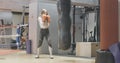 Wide shot of female boxer training on boxing ring. Portrait of slim beautiful brunette Caucasian woman fighting puching