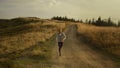 Fit guy running marathon in mountain landscape. Strong man jogging on dirty road Royalty Free Stock Photo