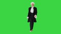 Man in old-fashioned laced frock coat and white wig walking in a mannered way looking at camera on a Green Screen