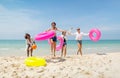 Wide shot group of teen girls bring swimming ring and run from the sea back to the beach during holiday or vacation relaxation