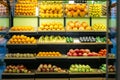 Wide shot of healthful fruits on grocery shelves. Multi-colored apples, pomegranates. tangerines, bananas and avocados