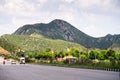 Wide shot of indian highway with trucks, cars, bikes, motorcycle and more on a wide asphalt road with green plants