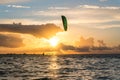 Wide shot of kitesurfer riding in yellow sunset conditions at the Greifswalder Bodden near the baltic sea