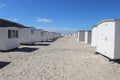 Wide shot of Lokken beach houses lined up on a beach on a hot and sunny day