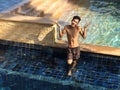 Wide shot of a male wearing a swimsuit standing in a pool Royalty Free Stock Photo