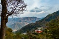 Wide shot of mountains under cloudy sky and tree in the foreground Royalty Free Stock Photo