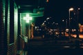 Wide shot of a neon green cross light signage hanging from a wall at night in a city Royalty Free Stock Photo