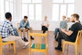 Wide shot portrait of senior male speaking on therapy meeting of addicts, sharing problem, giving support to teammates Royalty Free Stock Photo