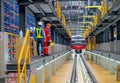 Wide shot professional engineer and technician workers walk beside railroad tracks of electrical or sky train in factory workplace Royalty Free Stock Photo