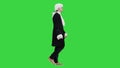 Man in old-fashioned laced frock coat and white wig walking in a mannered way looking at camera on a Green Screen