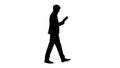 Silhouette Handsome businessman walking and working on a tablet.