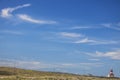 Wide shot of tourist landmark lighthouse on a hill in the Southern most point of Africa, Cape Agulhas.