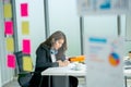 Wide shot through transparent board pretty young business woman use pen to write and note on paper in office and she look