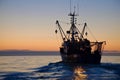 wide shot of a trawler with crew working at the break of dawn Royalty Free Stock Photo