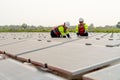 Wide shot of two technician workers sit and work on process of maintenance solar cell panel network system in concept of green Royalty Free Stock Photo
