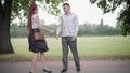 Wide shot of unpatient boyfriend meeting girlfriend in summer park. Young Caucasian couple leaving. Dating stress and