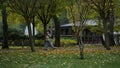 Wide shot of young walking couple going along scenic wood path in early autumn. Royalty Free Stock Photo