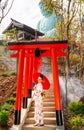 Wide shot of young woman wear japanese style dress also hold red umbrella stand on stair and look at camera with smiling in area Royalty Free Stock Photo