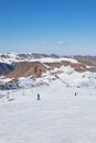 Wide ski track at resort. Skiers and snowboarders rolling down the slope of snowy mountain. Winter holiday activity