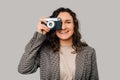 Wide smiling young woman is taking a picture with her old vintage camera. Royalty Free Stock Photo