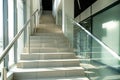 A wide staircase along the large windows in an office building. Modern interior of the lobby of an office building with large