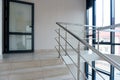 A wide staircase along the large windows in an office building. Modern interior of the lobby of an office building with large Royalty Free Stock Photo