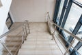 A wide staircase along the large windows in an office building. Modern interior of the lobby of an office building with large Royalty Free Stock Photo