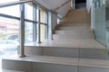 A wide staircase along the large windows in an office building. Modern interior of the lobby of an office building with large Royalty Free Stock Photo