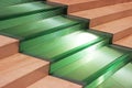 wide staircase with green glass steps between brown stone steps