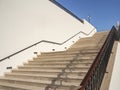 Wide staircase to the sky with stone steps along a light wall. Career growth concept.