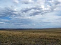 Wide steppe with yellow grass under a blue sky with white clouds Sayan mountains Siberia Russia Royalty Free Stock Photo