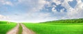 Wide summer landscape with meadow, road and scenic sky