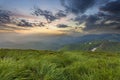 Wide summer mountain view at sunrise. Glowing orange sun raising Royalty Free Stock Photo