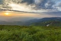 Wide summer mountain view at sunrise. Glowing orange sun raising Royalty Free Stock Photo