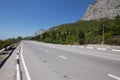 A wide track against the backdrop of endless deciduous forests and huge rocky mountains