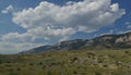 Upward shot of mountainside view with thick cotton clouds in the skies along North Fork Highway in Wyoming Royalty Free Stock Photo