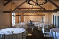 Wide view on banquet ball room in vintage style with lot of tables, chairs and theater scene