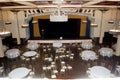 Wide view on banquet ball room in vintage style with lot of tables, chairs and theater scene