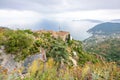 Wide view from castle to village buildings, sea and tourists walking on hill Royalty Free Stock Photo