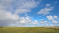 Wide view on Dutch landscape with sheep, meadow and cloudy skies Royalty Free Stock Photo