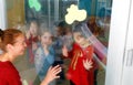 Wide view on fathers and sons gesture between the glass window in a preschool kindergarten