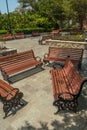 Wide view of group of unoccupied wooden seats or chairs arranged in a garden or park, Chennai, India, April 1st 2017