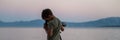 Boy exploring, looking through a telescope standing by the sea Royalty Free Stock Photo