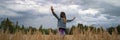 Woman celebrating life standing with her arms spread in the middle of wheat field Royalty Free Stock Photo