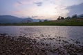 Wide view, low angle view, riverside scenery, mountains, evening sky, falling summer river, see small boulders