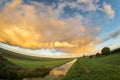 Wide view of a thundery shower over the dutch landscape at sunset. Royalty Free Stock Photo